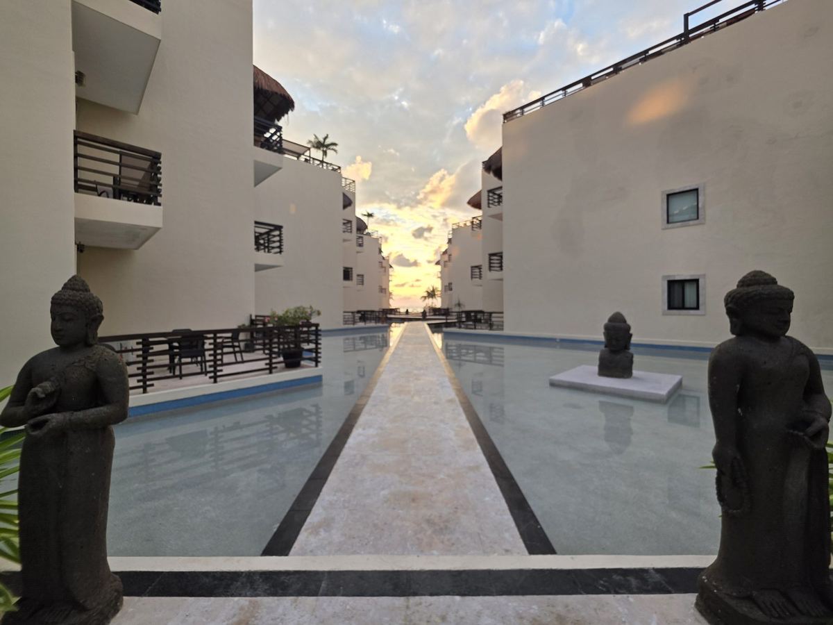 Budas de piedra de pie a los lados del andador del Espejo de Agua al amanecer